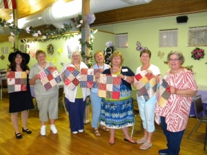Members of the Clifton Quilt guild holding nine-patches for Juliette's Hope Quilt. From left: Kim Verthelsen, Evelyn Post, Michele Kopack, Agnes Dembia, Dale Rice, Rosemary McGuire, and Jo Ann Tropiano.